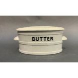 An early 20th century white pottery two handled butter dish, lettered in black
