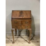 A reproduction mahogany bureau on cabriolelegs