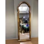 A cherrywood effect wall mirror, rectangular with arched profile