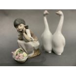 A Lladro figure of a girl sitting on an upturned wicker basket, a basket of flowers at her feet,