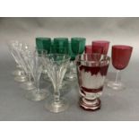 A set of six emerald green glass wines, three cranberry glass wines, five wines of slice cut in