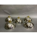 A set of five stainless steel and gilt metal food cloches