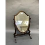 An early 20th century mahogany shield shaped toilet mirror