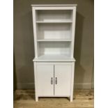 A pale grey cabinet with open shelves and two door cupboard below