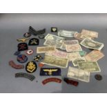 Tin of Military cloth badges plus small quantity of banknotes