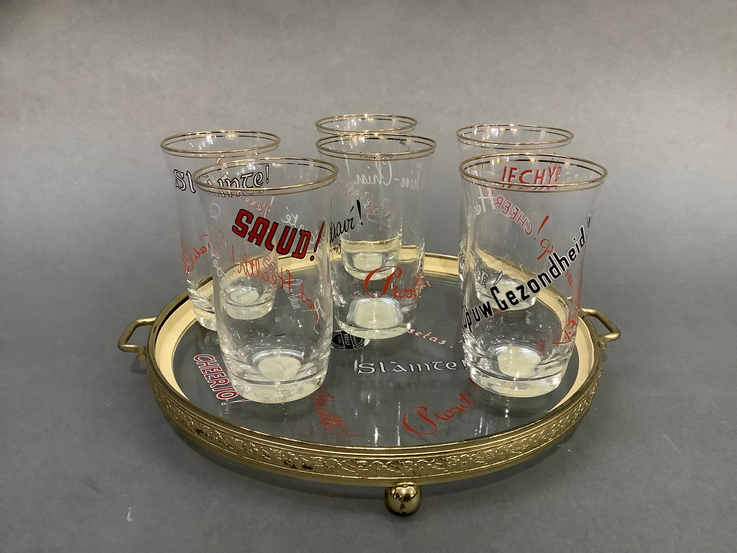 A 1950s glass and gilt metal drinks tray and six matching glasses