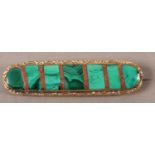 A Victorian malachite brooch, collet set within an elongated oval interspaced with strips of red