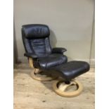 A Stressless type black leather effect swivel armchair and footstool