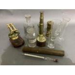 Four glass measuring flasks two labelled chemical bottles, old hydrometer, microscope, folding