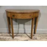 An oak semi circular hall table of narrow proportions with frieze drawer and on square chamfered