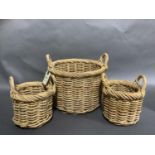 A large wicker two handled basket of circular outline and a pair of smaller two handled circu;ar