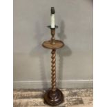 A walnut barley twist standard lamp with circular tier and base with bun feet