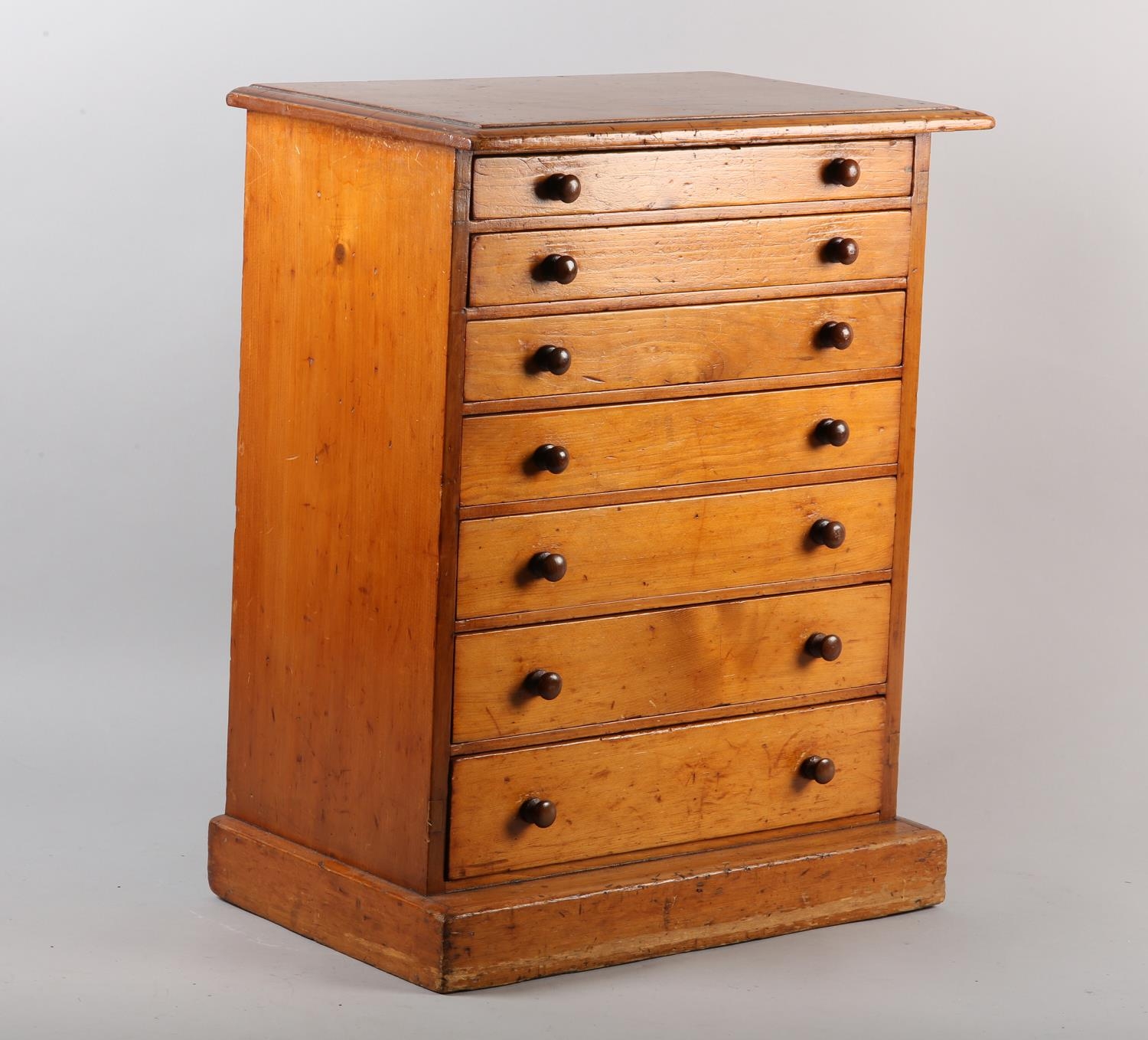 A Victorian mahogany specimen chest of seven graduated drawers with turned button handles, on plinth