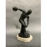 A cast sculpture after the antique of discus thrower raised on an oval base and marble effect plinth