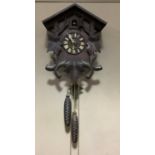 A Black Forest style cuckoo clock with cast pine cone weights