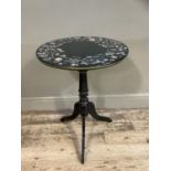 An ebonised circular pedestal table with floral decoupage border to the surface
