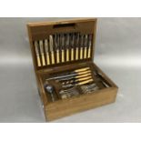 An oak canteen of cutlery for six settings including dinner knives and forks, entree knives and
