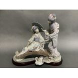 A large Lladro group of two Geishas, one sitting on a bridge with a parasol, the other standing