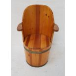 PINE BARREL ARMCHAIR with a shaped back and arms above a circular removable seat with storage below,