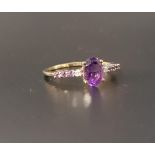 AMETHYST AND DIAMOND RING the central oval cut amethyst flanked by a diamond and three amethysts