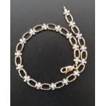 DIAMOND SET NINE CARAT GOLD BRACELET with alternating diamond set cross shaped links and pierced