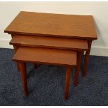 NEST OF TEAK TABLES with rectangular tops, standing on tapering supports, 39cm high