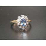 BLUE TOPAZ AND DIAMOND CLUSTER RING the central bezel set oval cut blue topaz approximately 0.