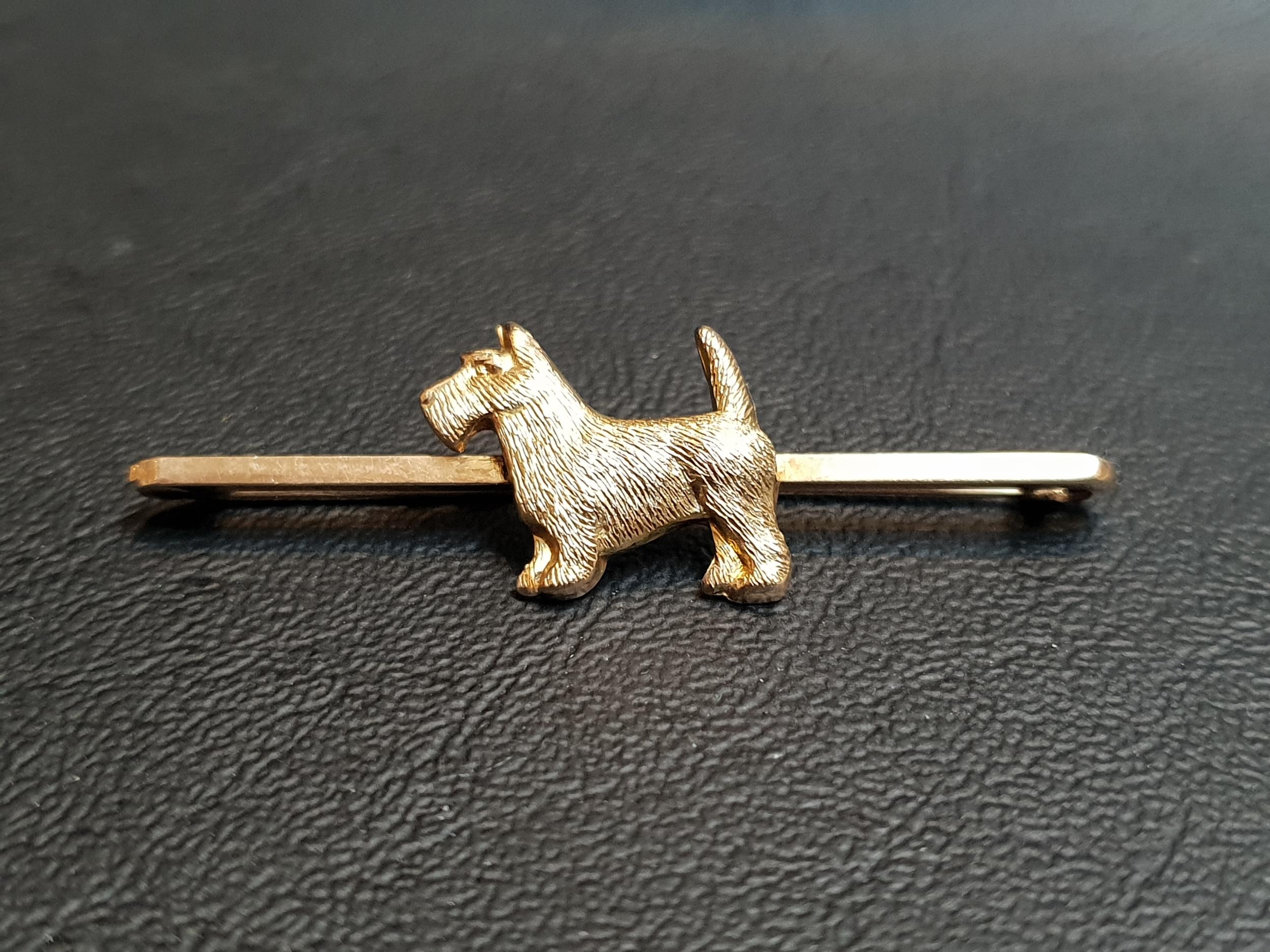 NINE CARAT GOLD TERRIER BROOCH the Fox Terrier set to the centre of the bar, 5.2cm long and