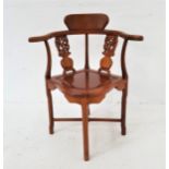 CHINESE HARDWOOD CORNER CHAIR with a shaped back and bowed arm rail above carved and pierced splats,