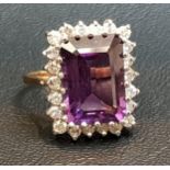 IMPRESSIVE AMETHYST AND DIAMOND CLUSTER RING the central emerald cut amethyst measuring