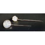 TWO MOONSTONE SET STICK PINS both in unmarked gold, one with moonstone ball finial and overlaid gold