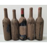 FIVE BOTTLES OF UNKNOWN RED WINE all covered in a layer of dirt resulting in the labels being