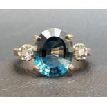 BLUE TOPAZ AND SAPPHIRE THREE STONE RING the central oval cut topaz approximately 4.8cts, flanked by