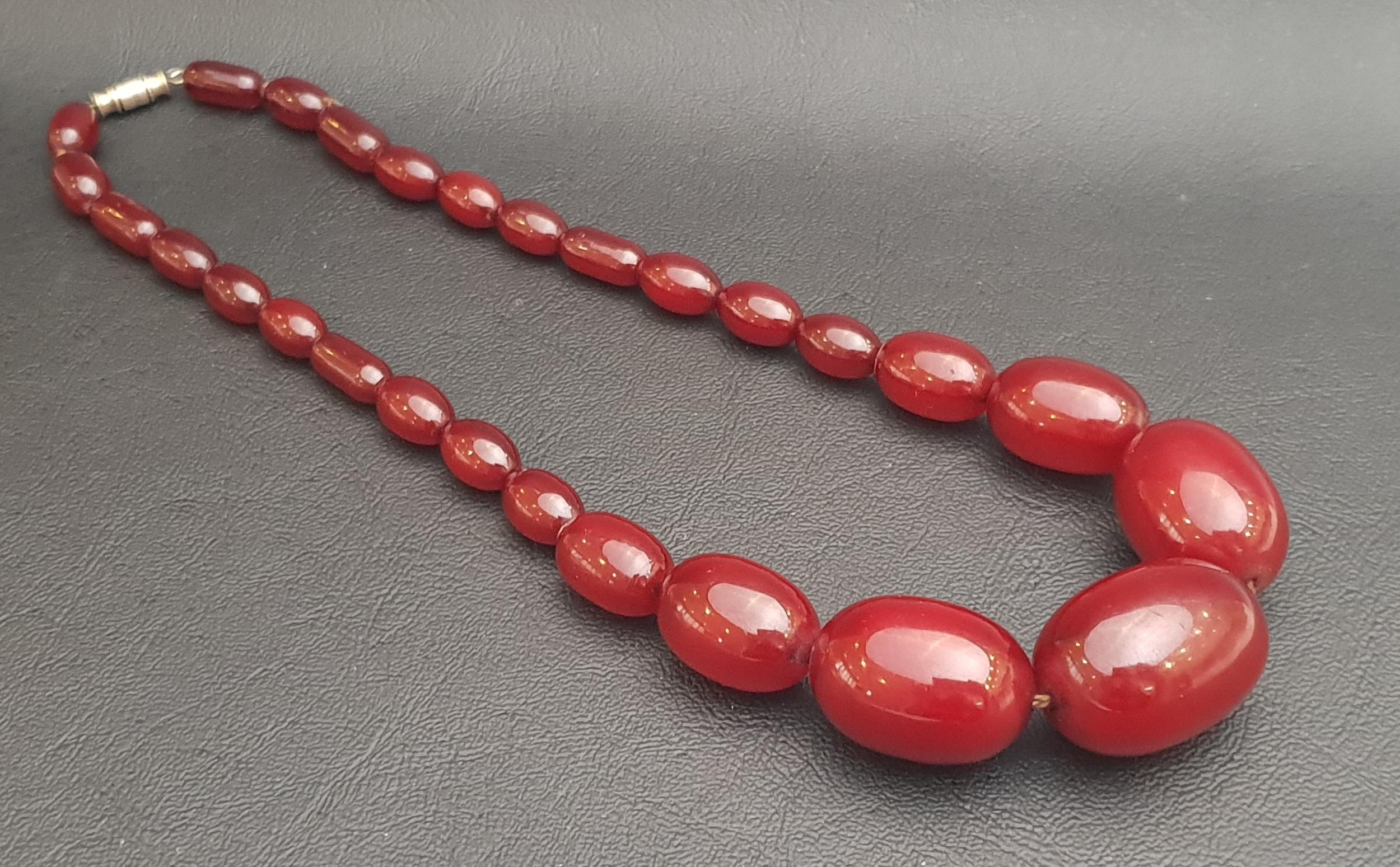 GRADUATED AMBER BEAD NECKLACE the largest approximately 2.8cm wide and 1.8cm diameter, total weigh