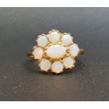 OPAL CLUSTER RING the central oval cabochon opal in eight round cabochon opal surround, on nine