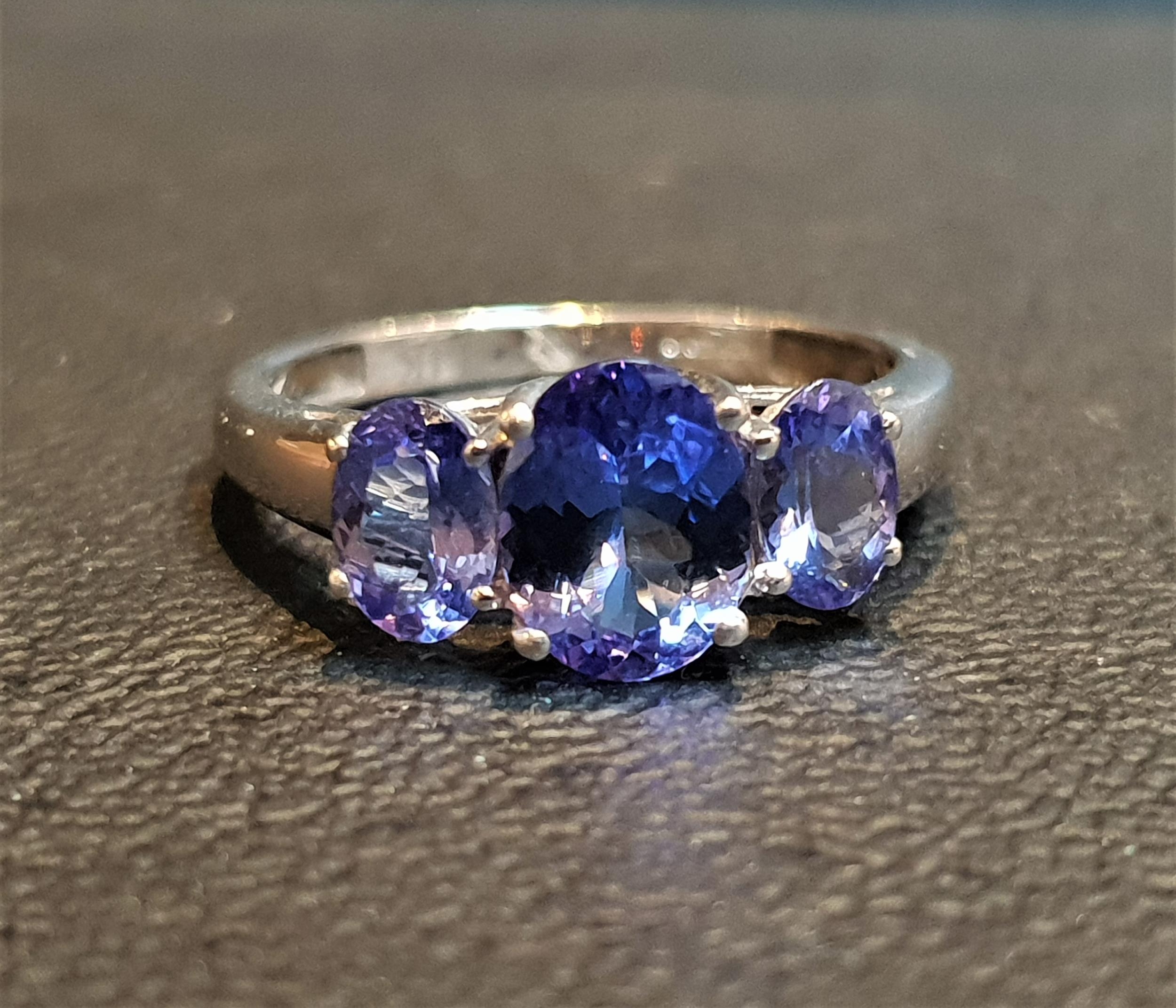 IMPRESSIVE TANZANITE THREE STONE RING the central oval cut tanzanite approximately 1ct flanked by