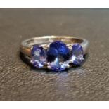 IMPRESSIVE TANZANITE THREE STONE RING the central oval cut tanzanite approximately 1ct flanked by