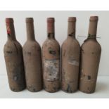 FIVE BOTTLES OF UNKNOWN RED WINE all covered in a layer of dirt resulting in the labels being