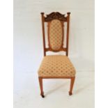 OAK DINING CHAIR with a shaped and carved top rail above an oval padded back above a stuffover seat,