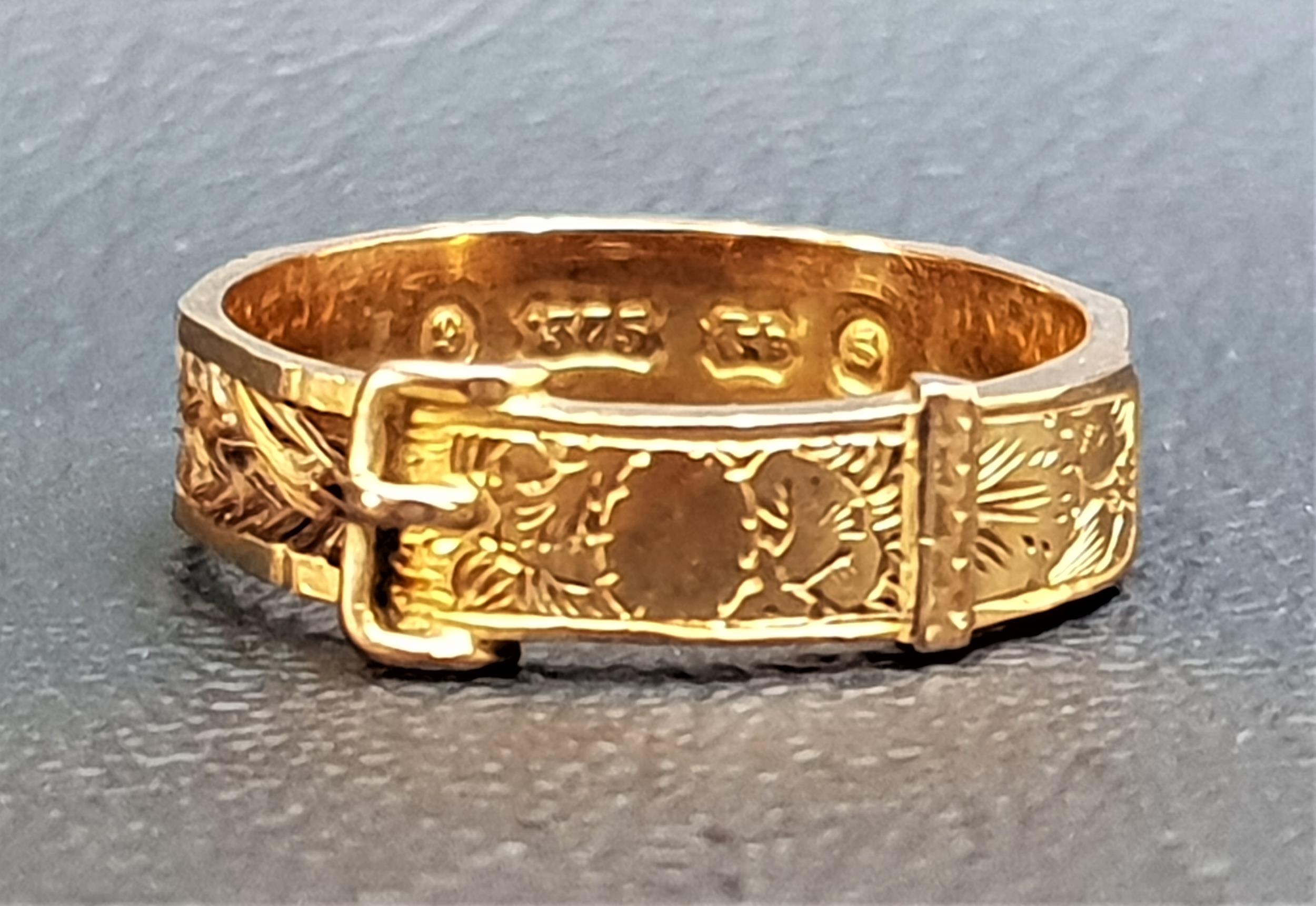 VICTORIAN NINE CARAT GOLD MOURNING RING of buckle design with entwined hair around the shank,