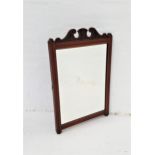 EDWARDIAN MAHOGANY WALL MIRROR with a carved frame and a bevelled plate, originally from a