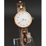 LADIES NINE CART GOLD CASED WRISTWATCH the white dial with black Arabic numerals and gilt