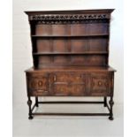 OAK DRESSER with a plain pediment above a carved and pierced frieze with two shelves below, the base