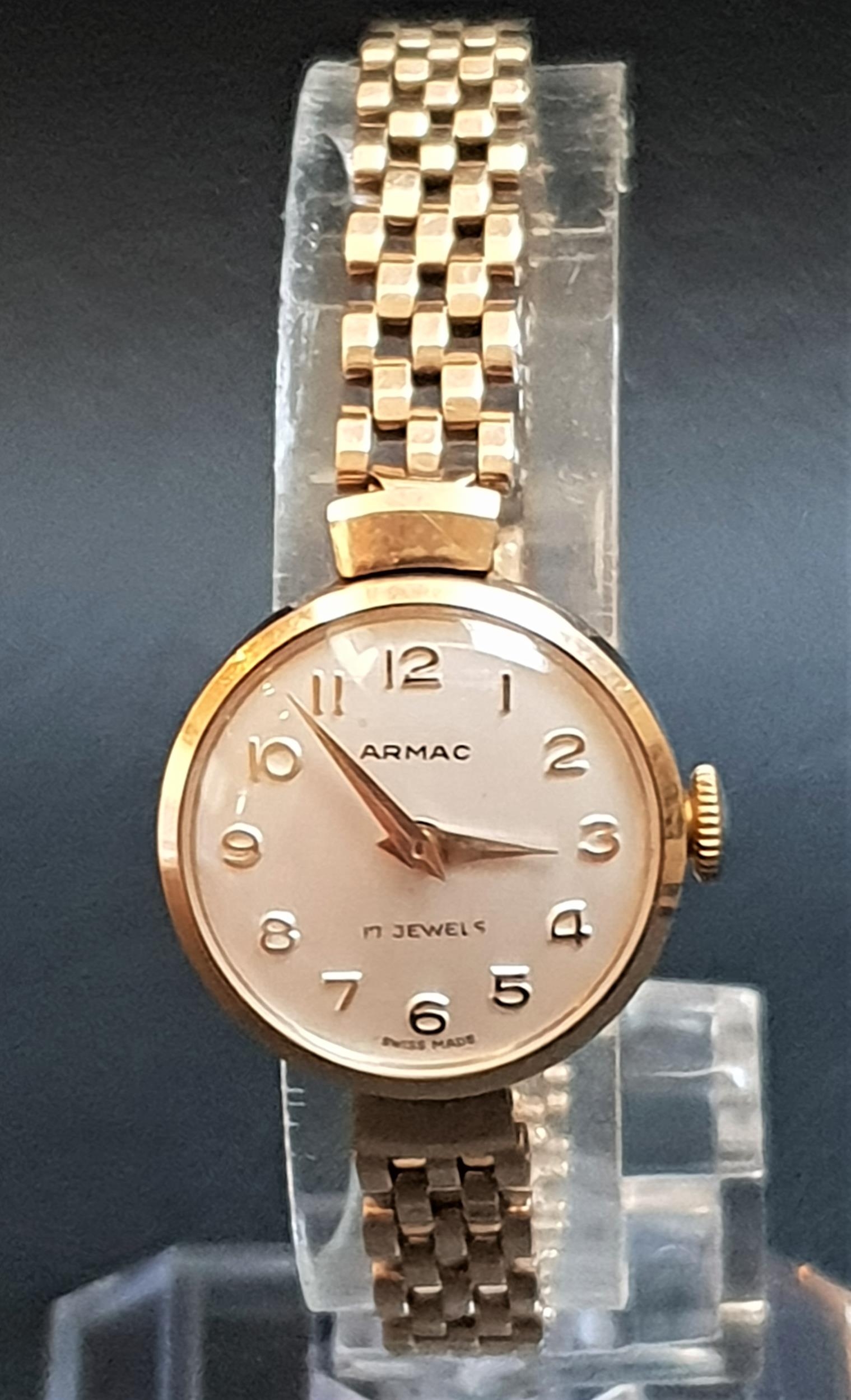 LADIES ARMAC NINE CARAT GOLD WRISTWATCH the circular dial with gilt Arabic numerals, on nine carat