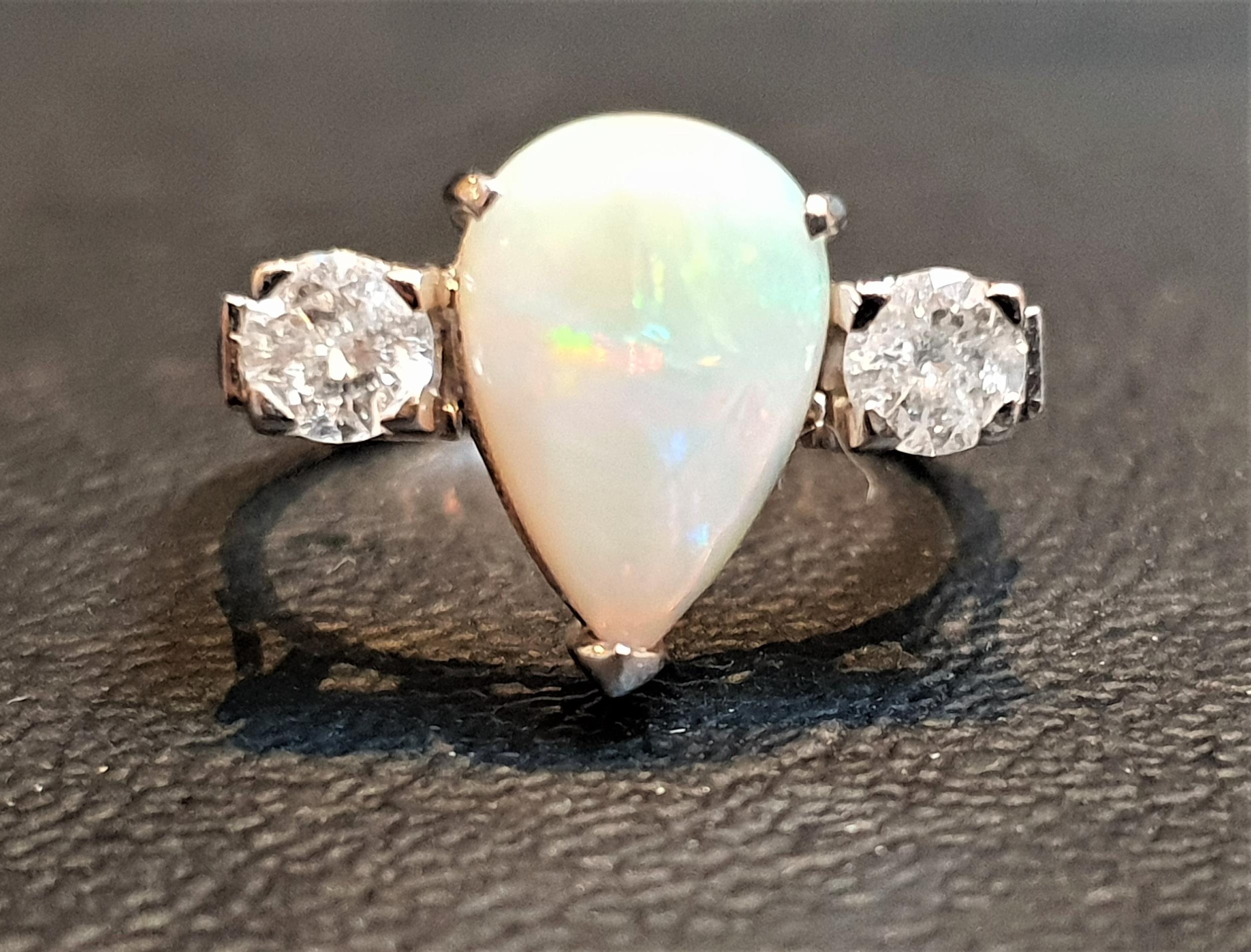 OPAL AND DIAMOND THREE STONE RING the central pear cabochon opal flanked by round cut diamonds