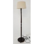 STAINED WOOD STANDARD LAMP raised on a circular base with a turned column and white hessian shade,