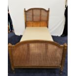 EARLY 20th CENTURY CARVED SINGLE BED with a shaped gilt rattan head and footboard, standing on