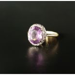 AMETHYST AND DIAMOND CLUSTER RING the central oval cut amethyst measuring approximately 10mm x 7.8mm