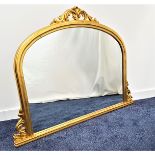 GILTWOOD ARCHED OVER MANTLE MIRROR with carved decoration, 90cm x 125cm