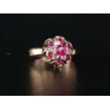 RUBY AND CLEAR GEM SET CLUSTER RING on nine carat gold shank with pierced mount (one clear